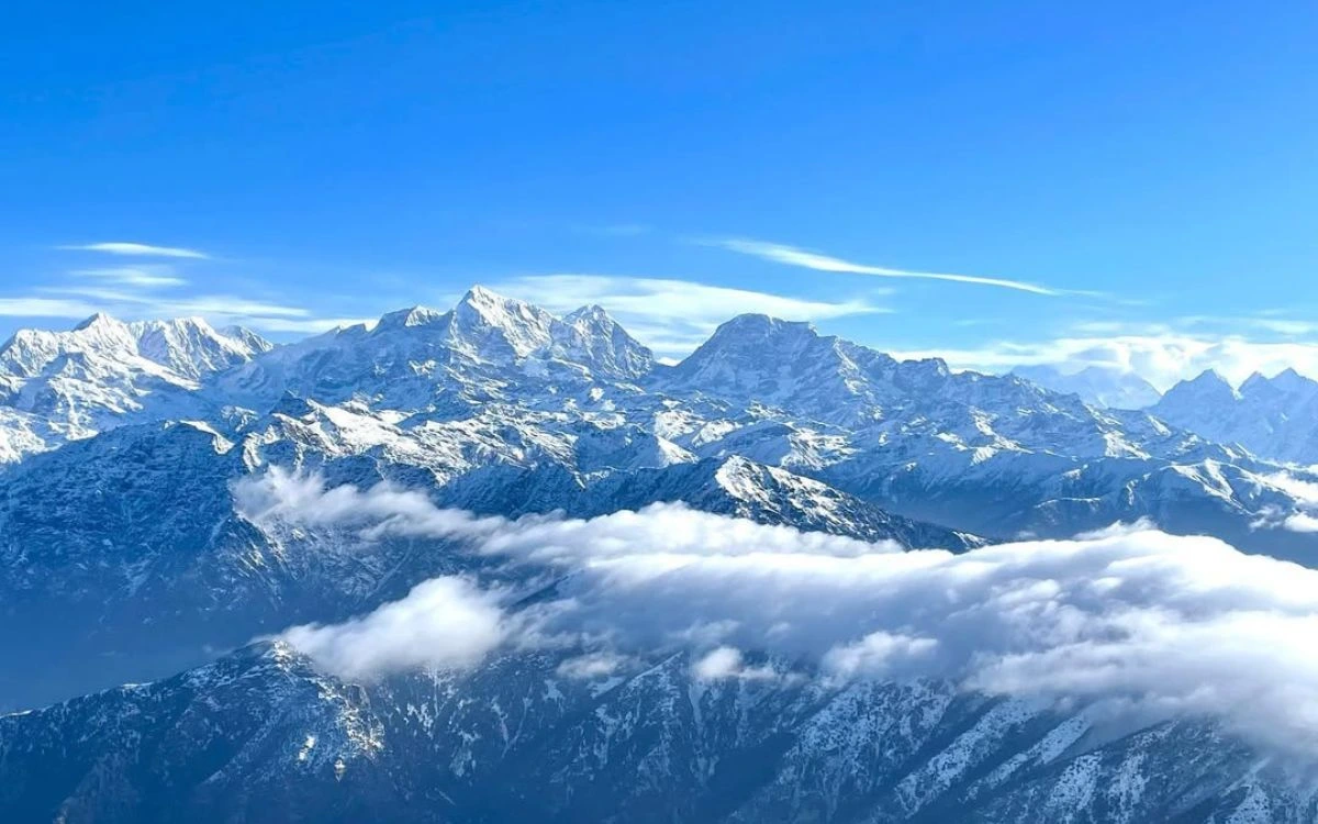 Snow-capped Himalayan peaks rising above clouds from Pikey Peak