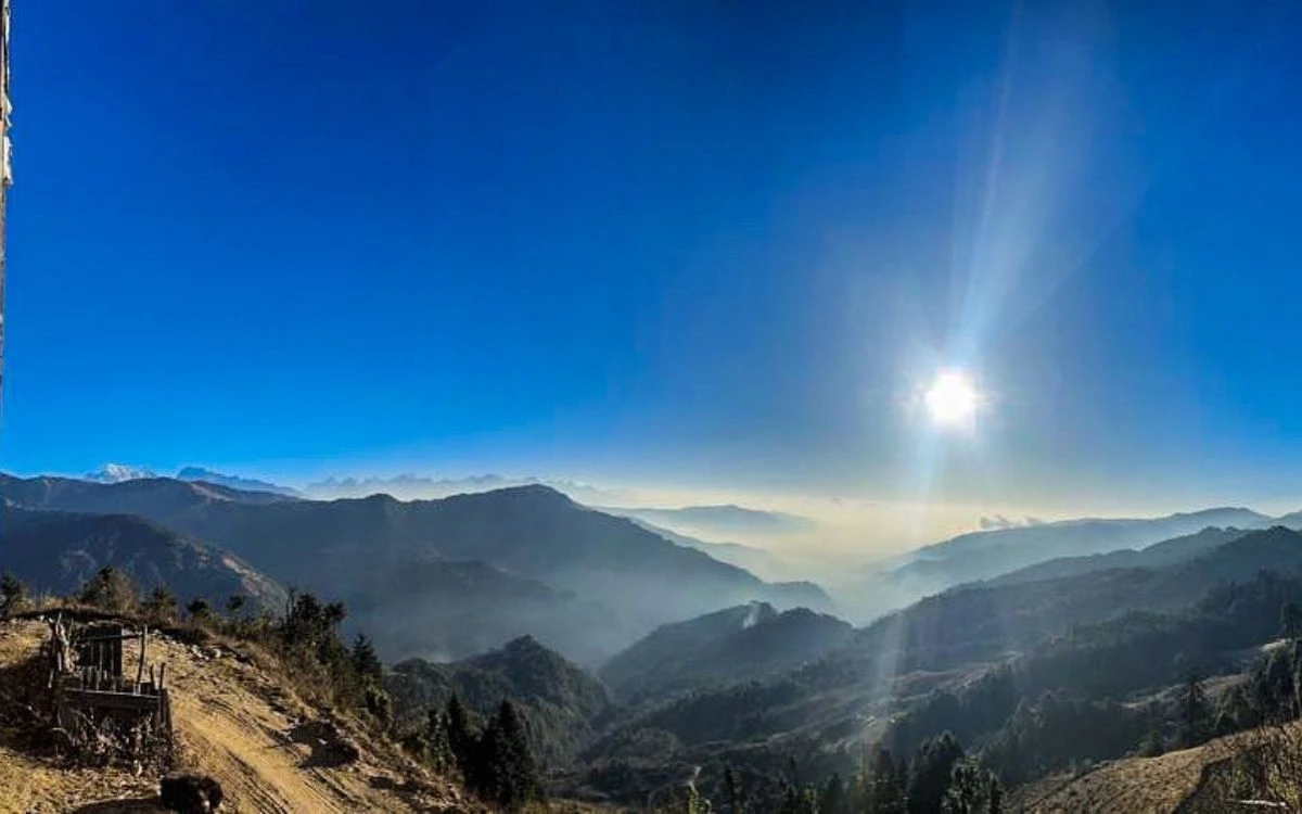 Misty valley view with sun rays breaking through mountains on Pikey Peak trek