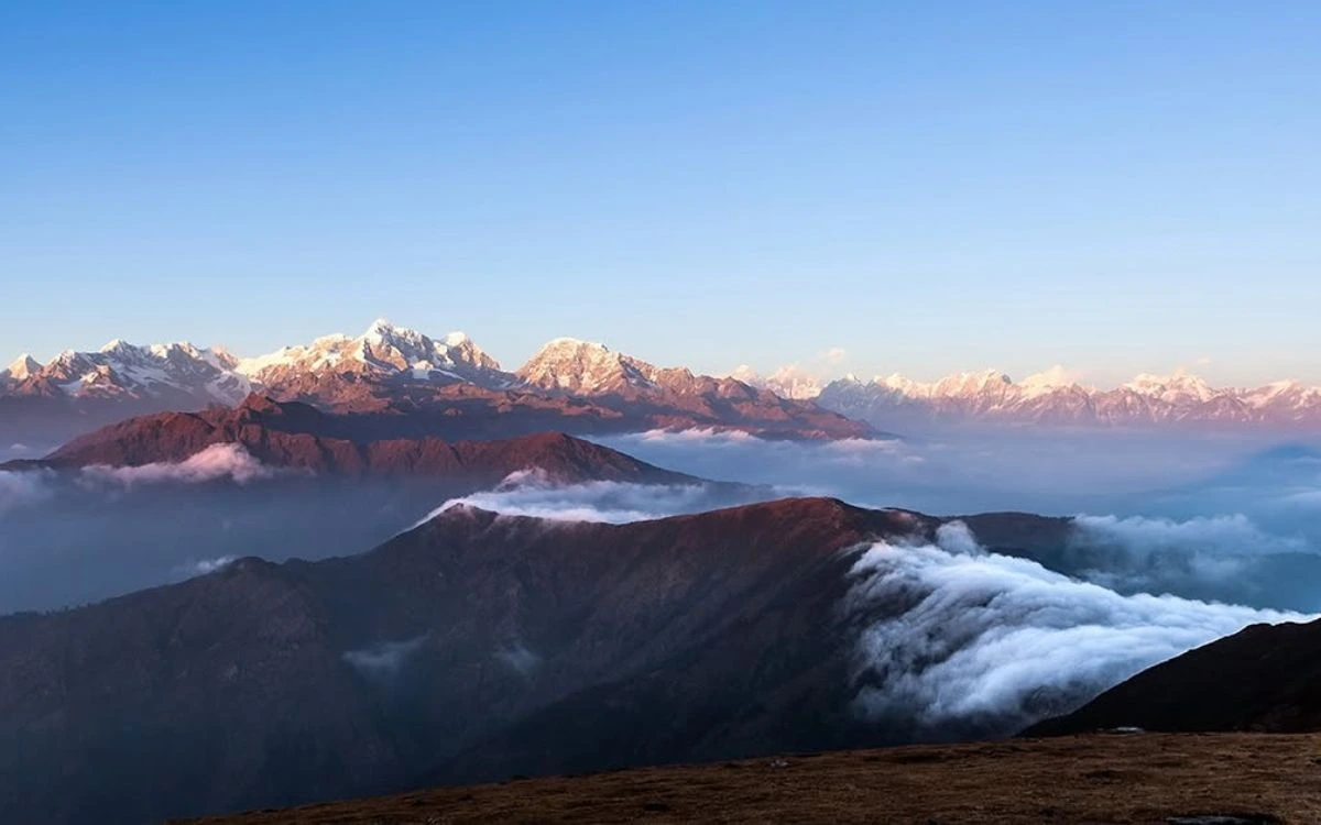 Sunrise illuminating Himalayan mountain range with sea of clouds below