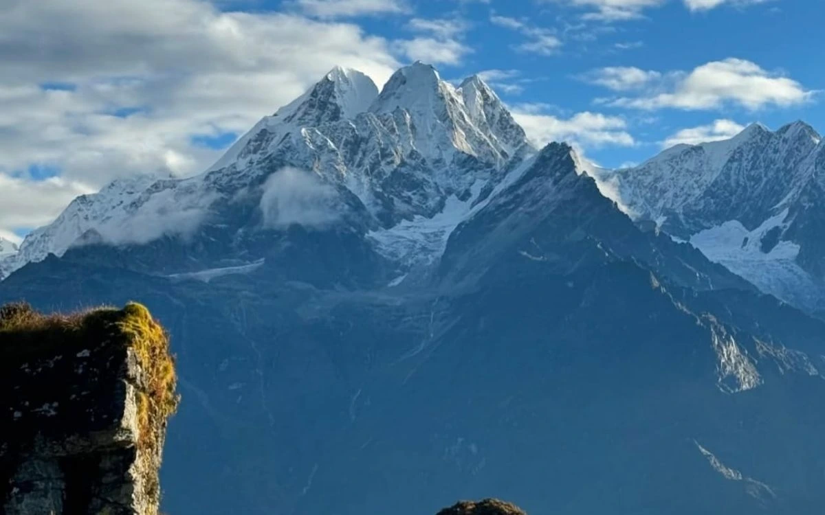 Snow-covered mountain range seen from a rocky viewpoint in Nepal
