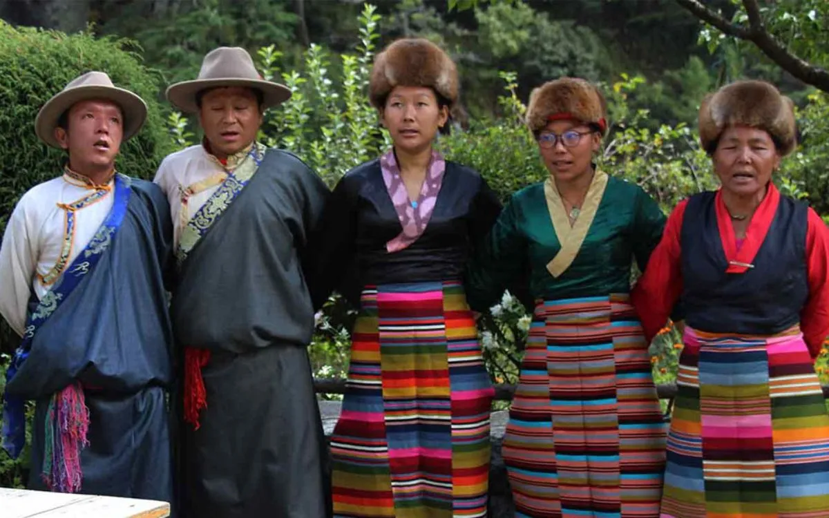Sherpa women wearing colorful striped aprons and traditional dress during cultural ceremony