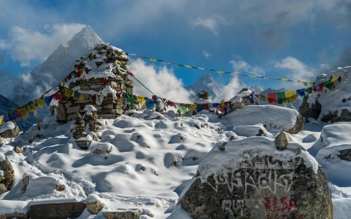 Snow-covered stone chorten with prayer flags in the Everest region