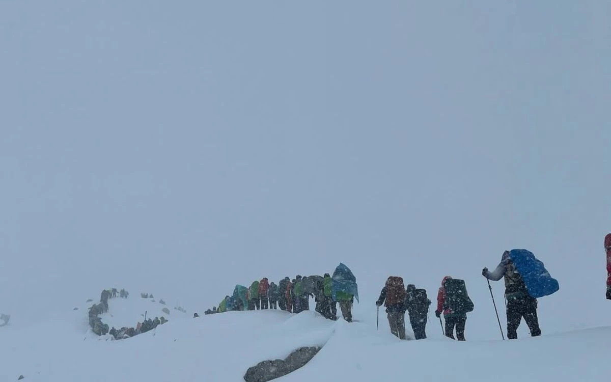 Group of trekkers hiking through deep snow on Manaslu trek in bad weather