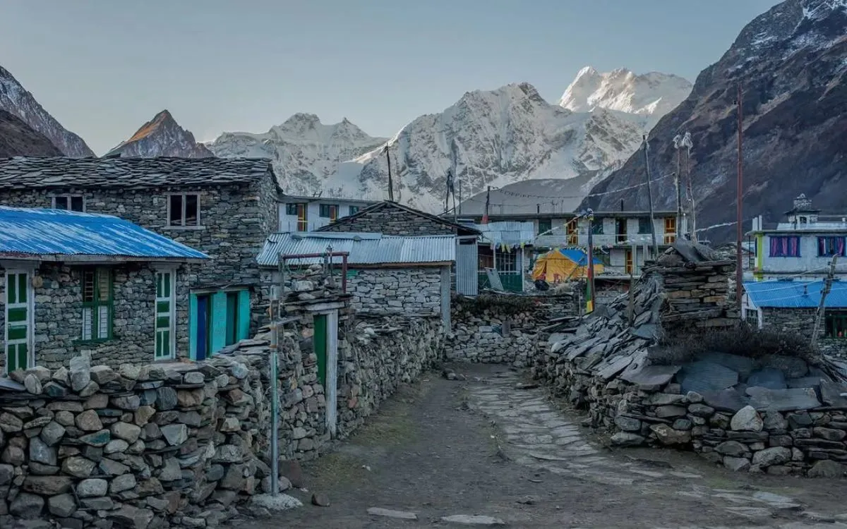 Stone teahouse village with mountain backdrop at dusk in Manalsu Circuit Trek