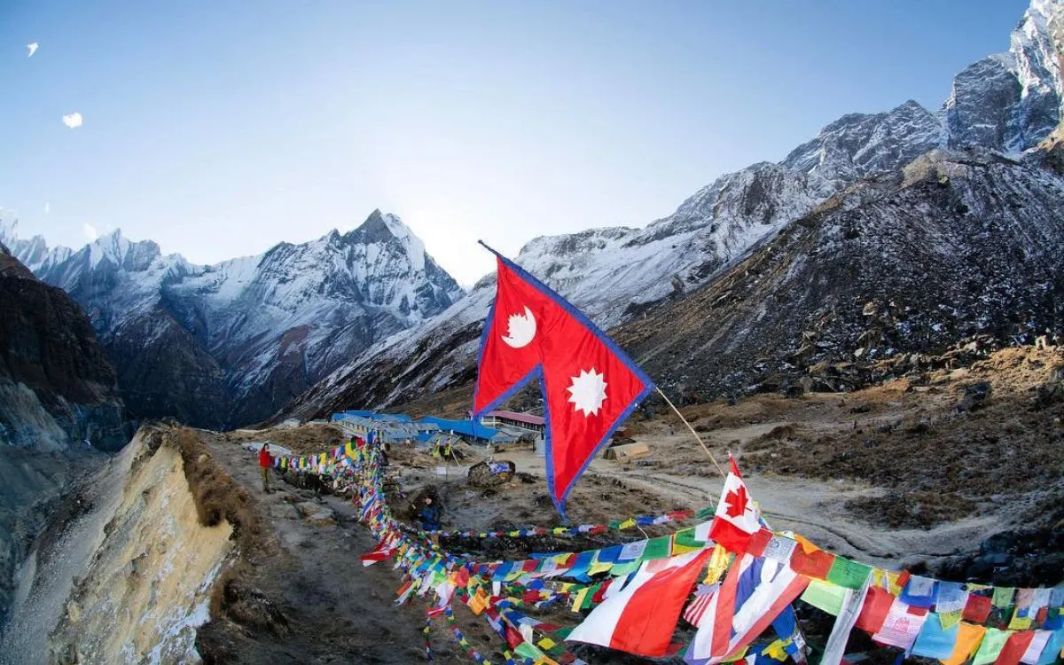 Nepal flag displayed in Himalayan valley with colorful prayer flags