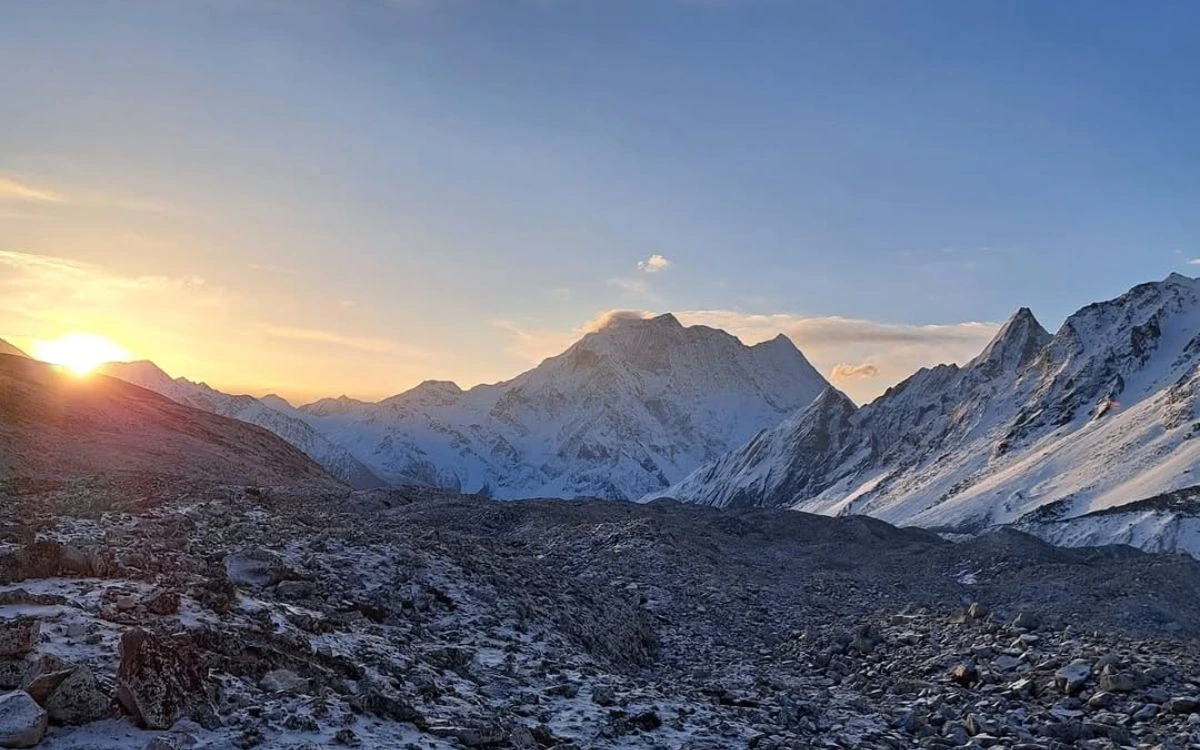 Sunrise over a glacial moraine valley surrounded by towering Himalayan peaks
