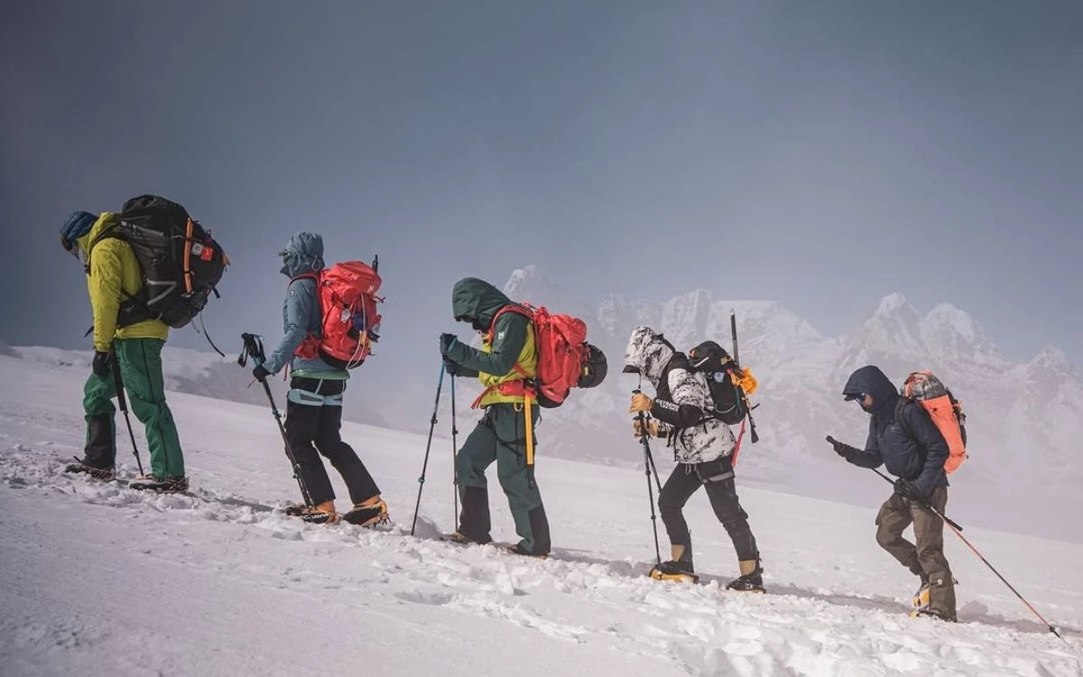 Trekkers crossing a snowy ridge in Nepal during December