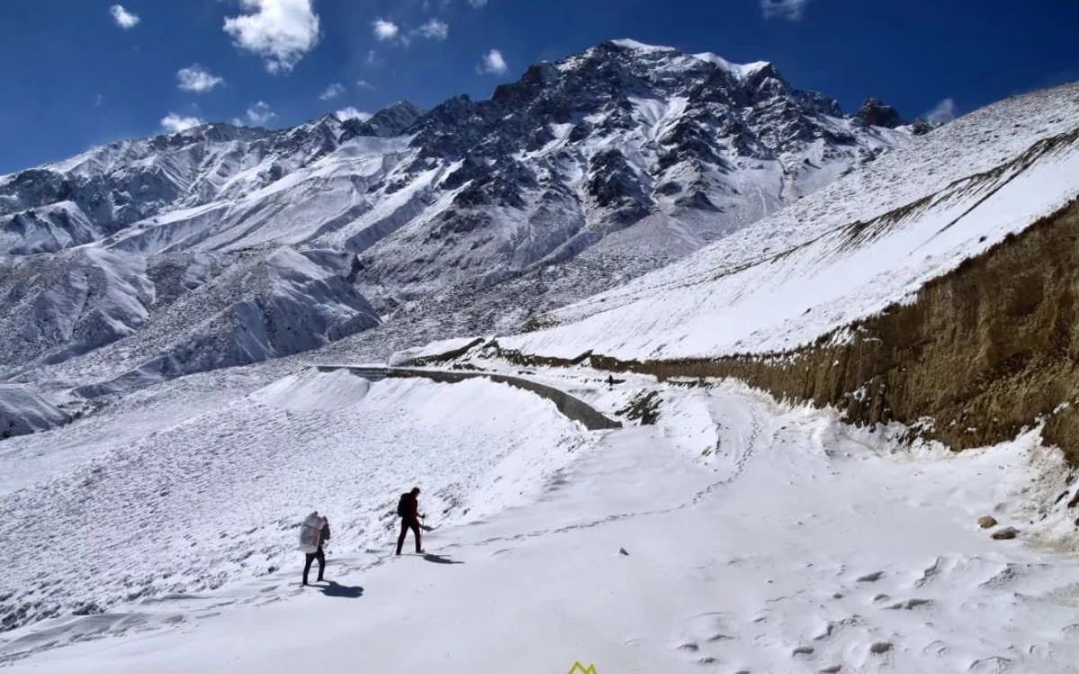 Snow-covered trail below high peaks on a December trek in Nepal