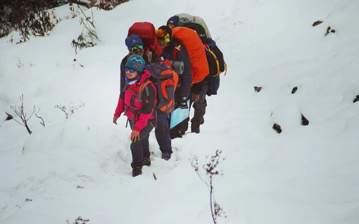 Trekkers descending a snowy slope in Nepal in December