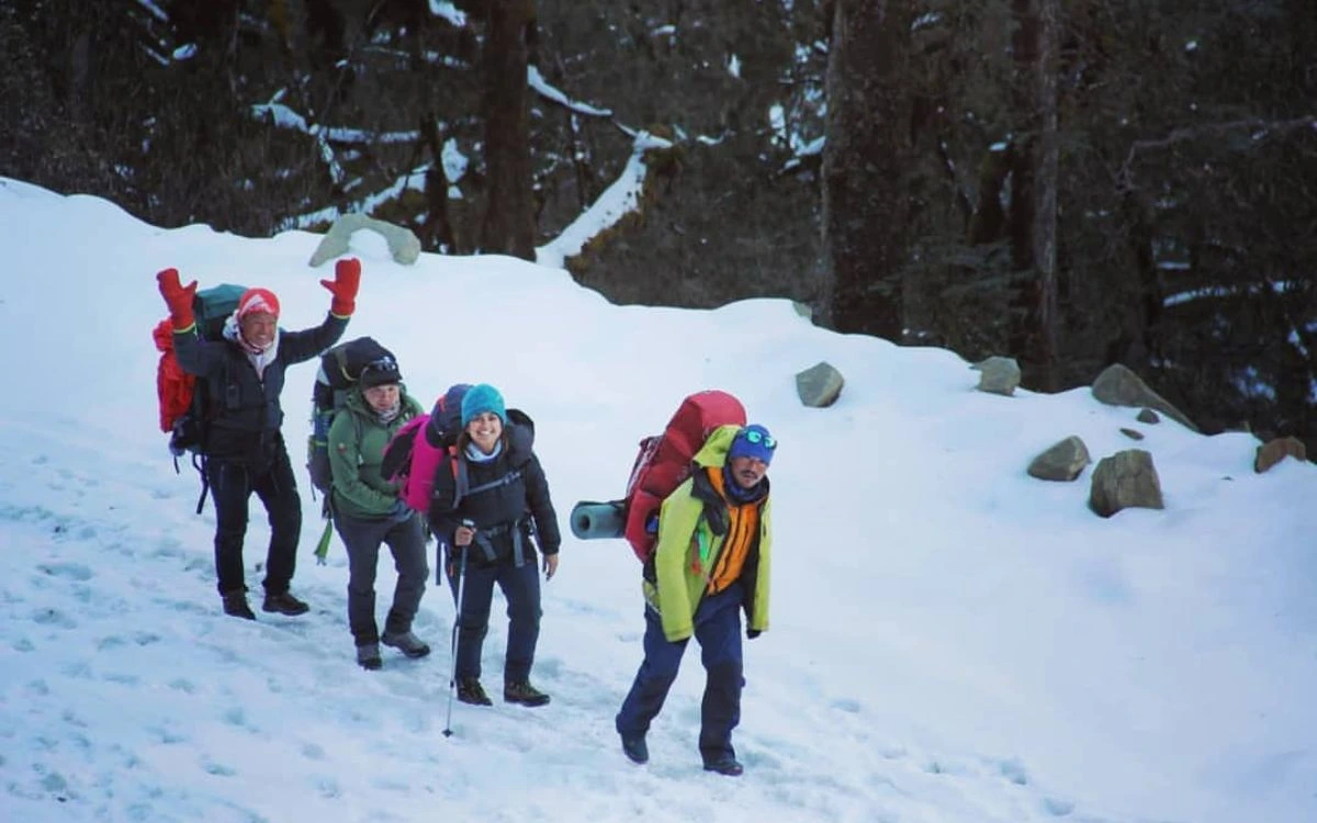 Happy trekkers on a snowy forest trail in Nepal in December