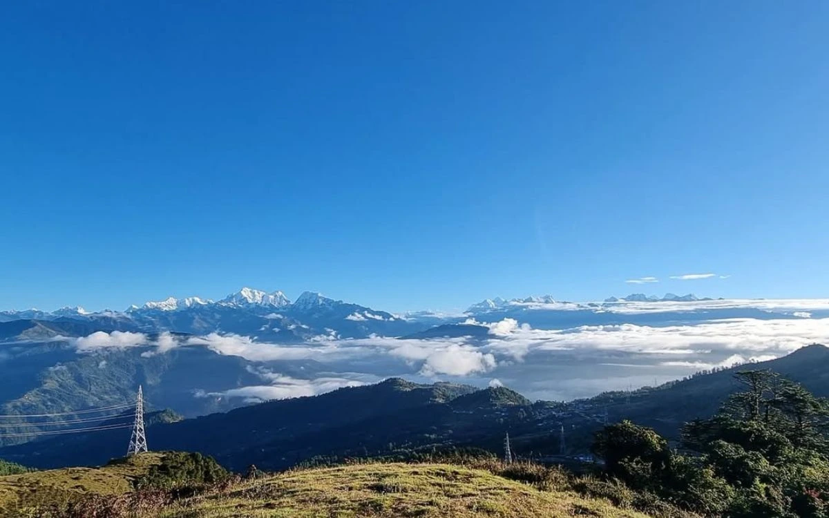 Panoramic view of Himalayan mountain range with snow-capped peaks above clouds