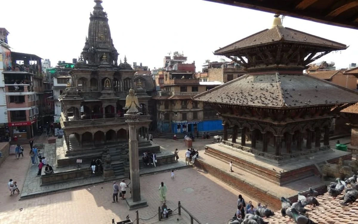 Ancient Hindu temples and a stone pillar at Patan Durbar Square in Lalitpur, Nepal