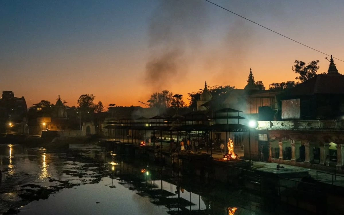 Cremation fires and smoke rising at the Pashupatinath Temple ghats along the Bagmati River at dusk