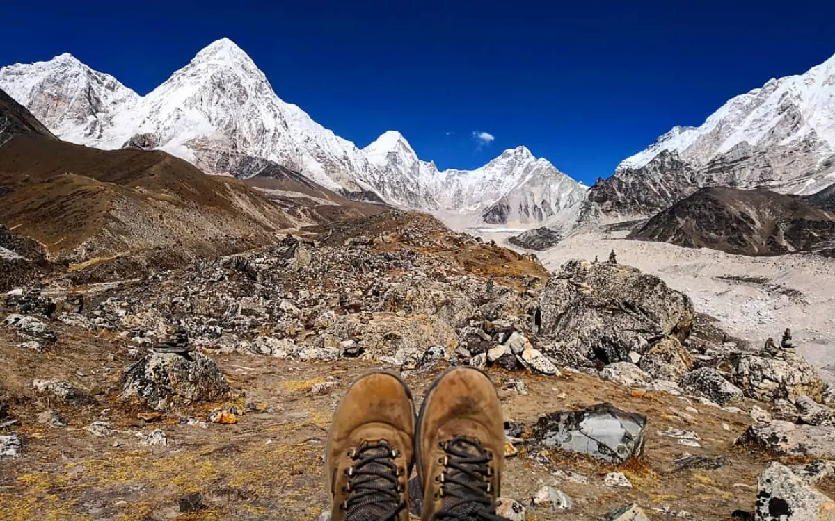 Hiking boots overlooking Everest Base Camp with snow-capped Himalayan peaks