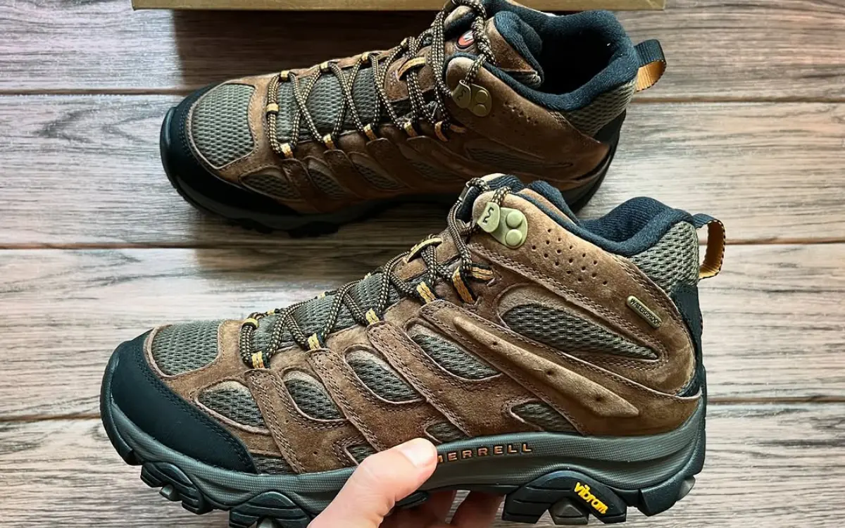 Merrell Moab hiking boots with Vibram soles on wooden surface