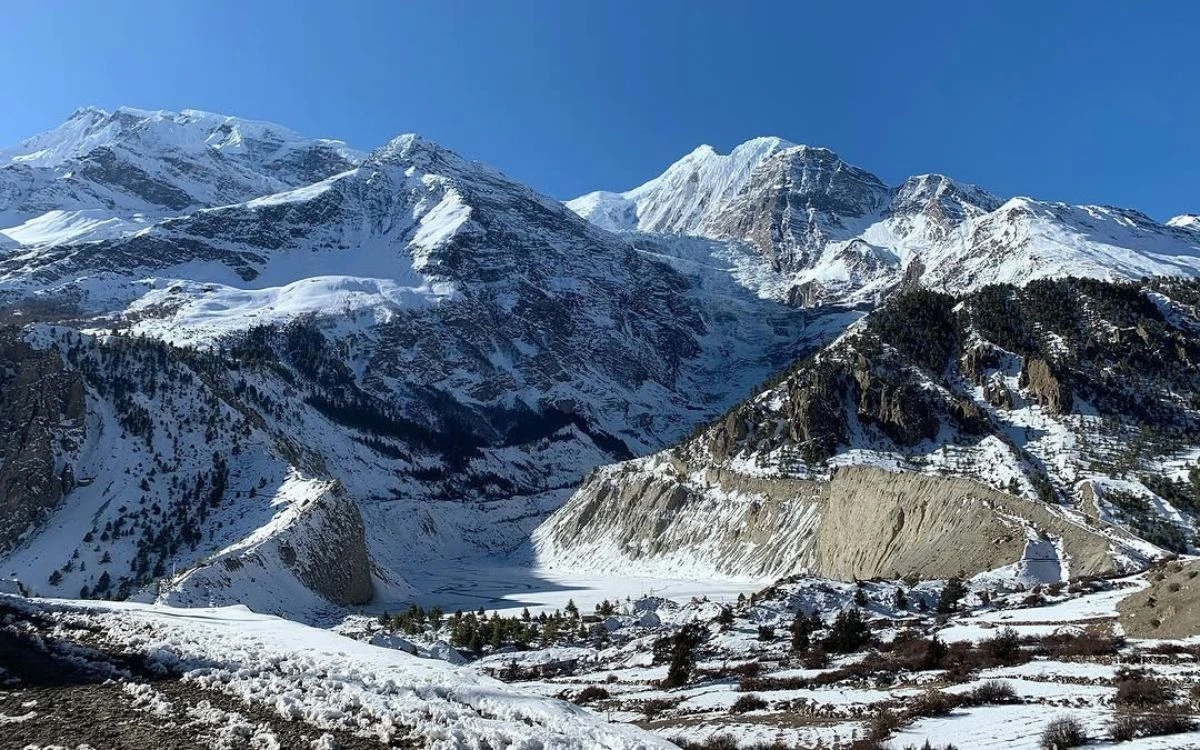 now-covered Himalayan peaks and a frozen lake in the valley near Yak Kharka