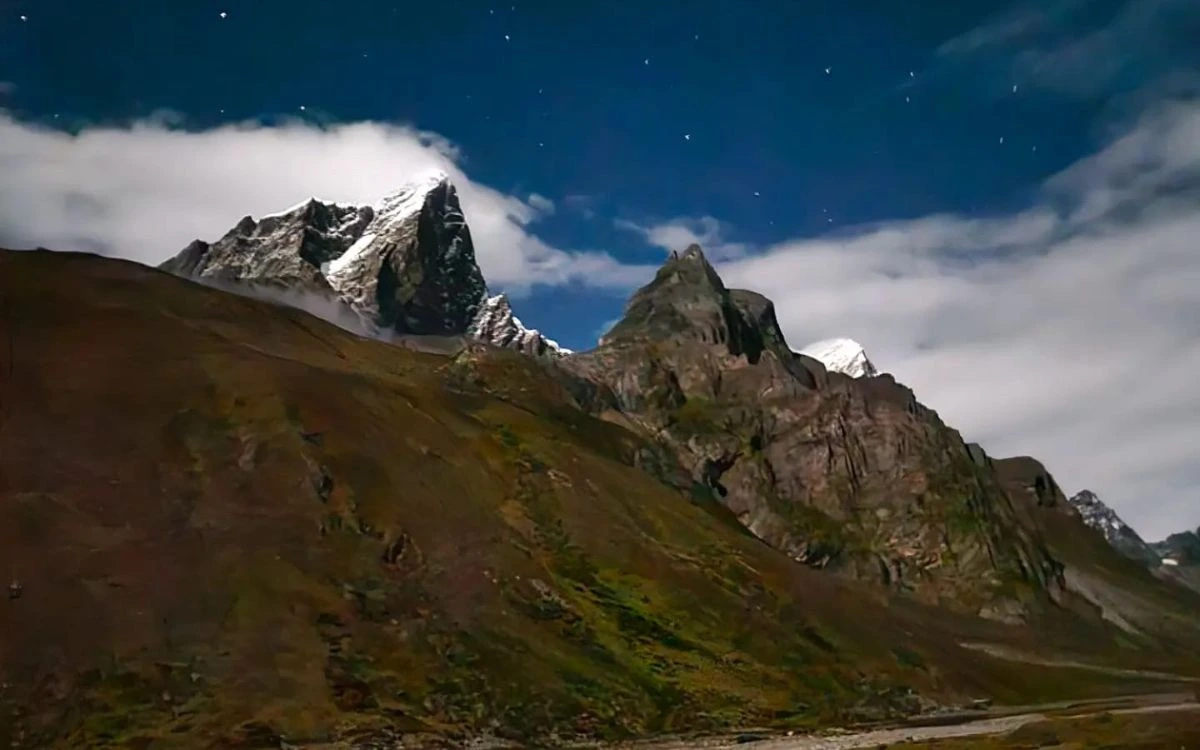 Himalayan peak with reduced snow cover under a starry night sky, reflecting climate change