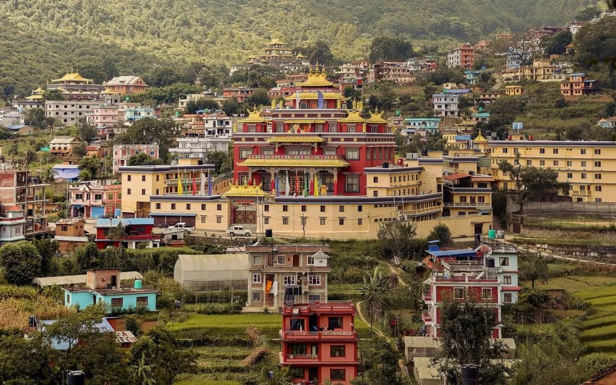 The vibrant Neydo Tashi Chöling Monastery surrounded by the colorful residential buildings of Pharping village.