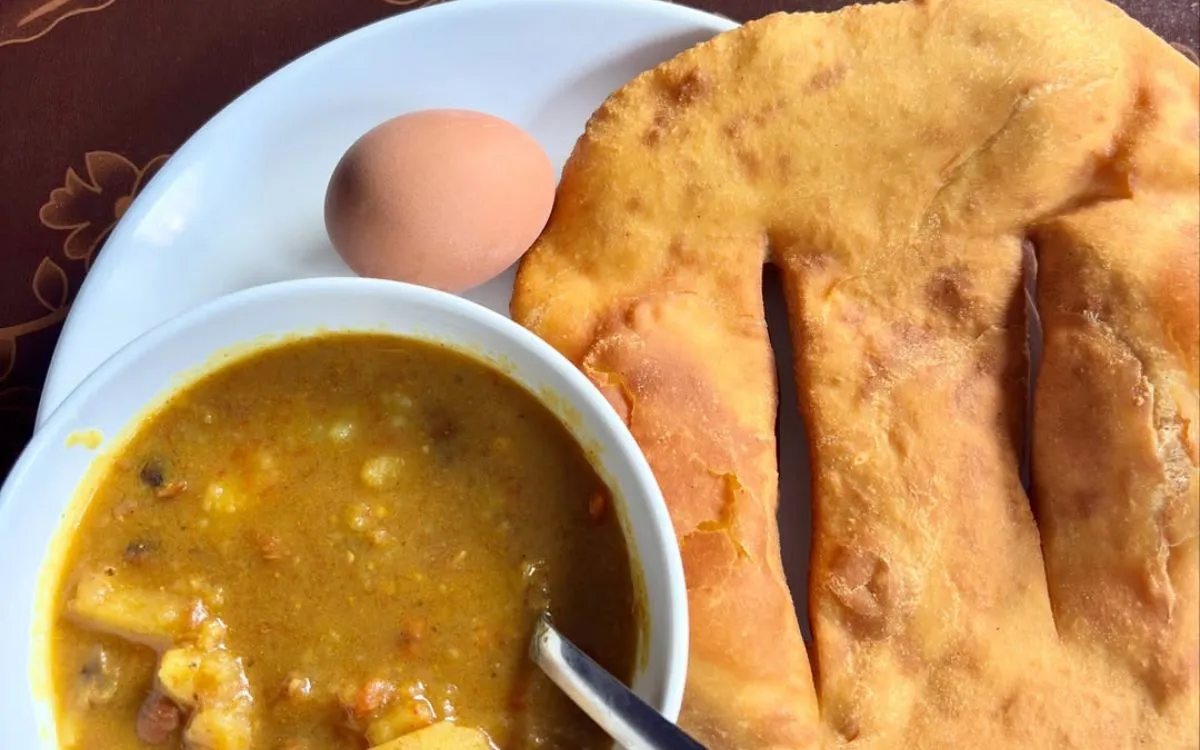 Tibetan bread with boiled egg and vegetable curry soup served on white plate
