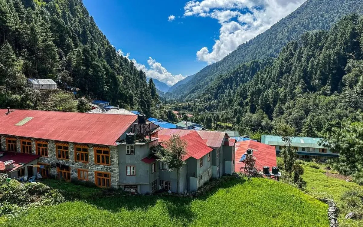 Mountain village houses with red roofs surrounded by green forests and hills