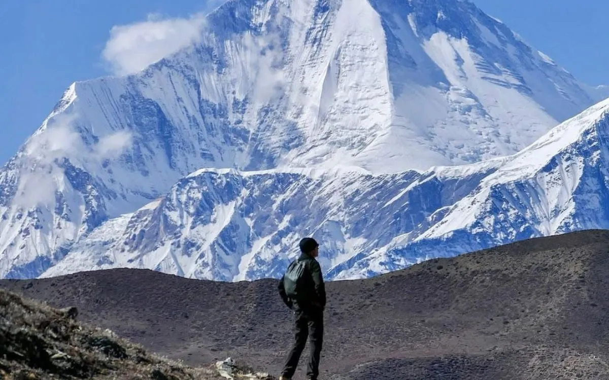 Solo trekker views Everest region peaks - high-altitude trekking adventure in Nepal Himalayas
