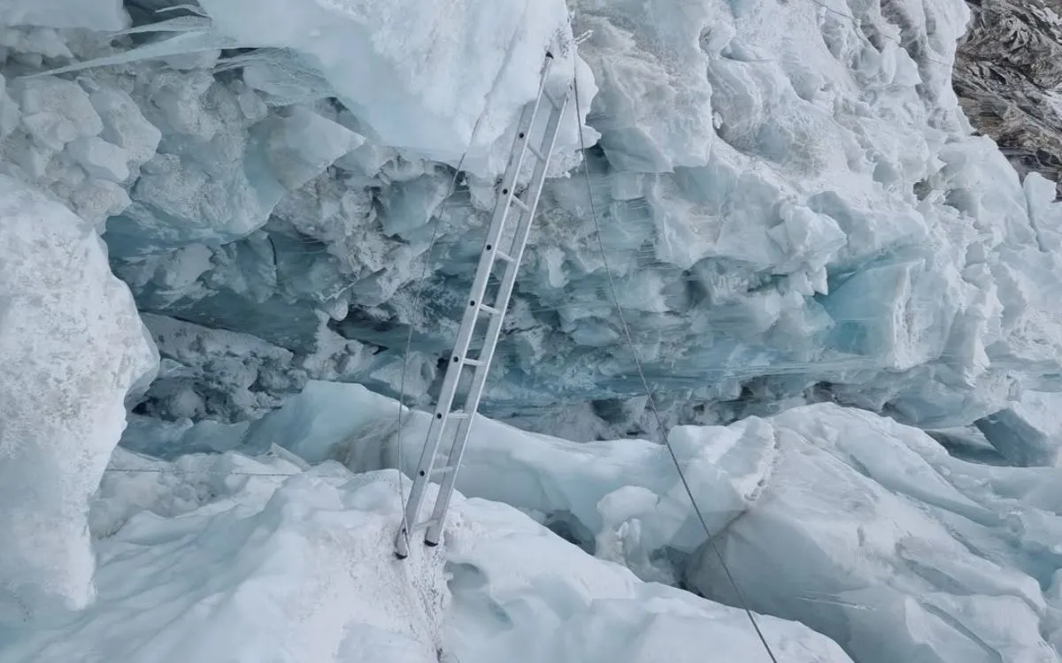 Aluminum ladder spanning dangerous crevasse in Khumbu Icefall glacier on Everest climbing route