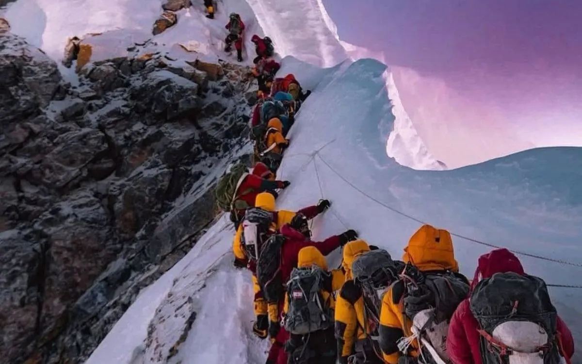 Climbers waiting in line near the top of Mount Everest at sunrise