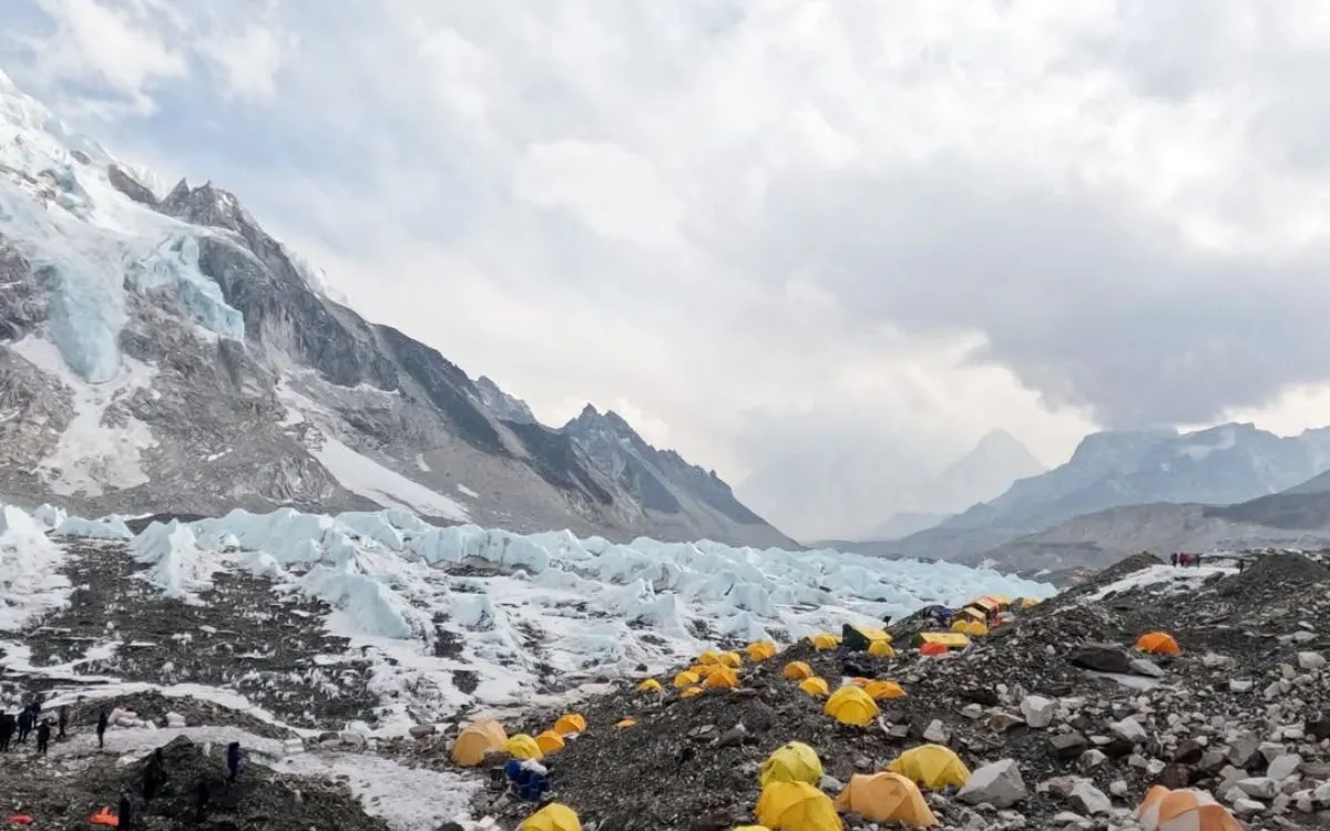 Mount Everest Base Camp expedition tents scattered across rocky moraine with glacier and mountains