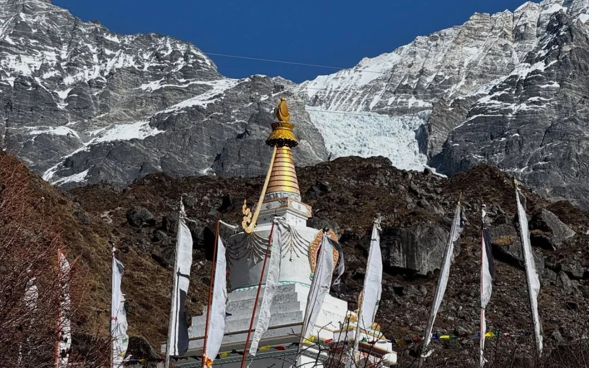 Buddhist stupa with prayer flags against snow-capped mountains and glacier in Langtang