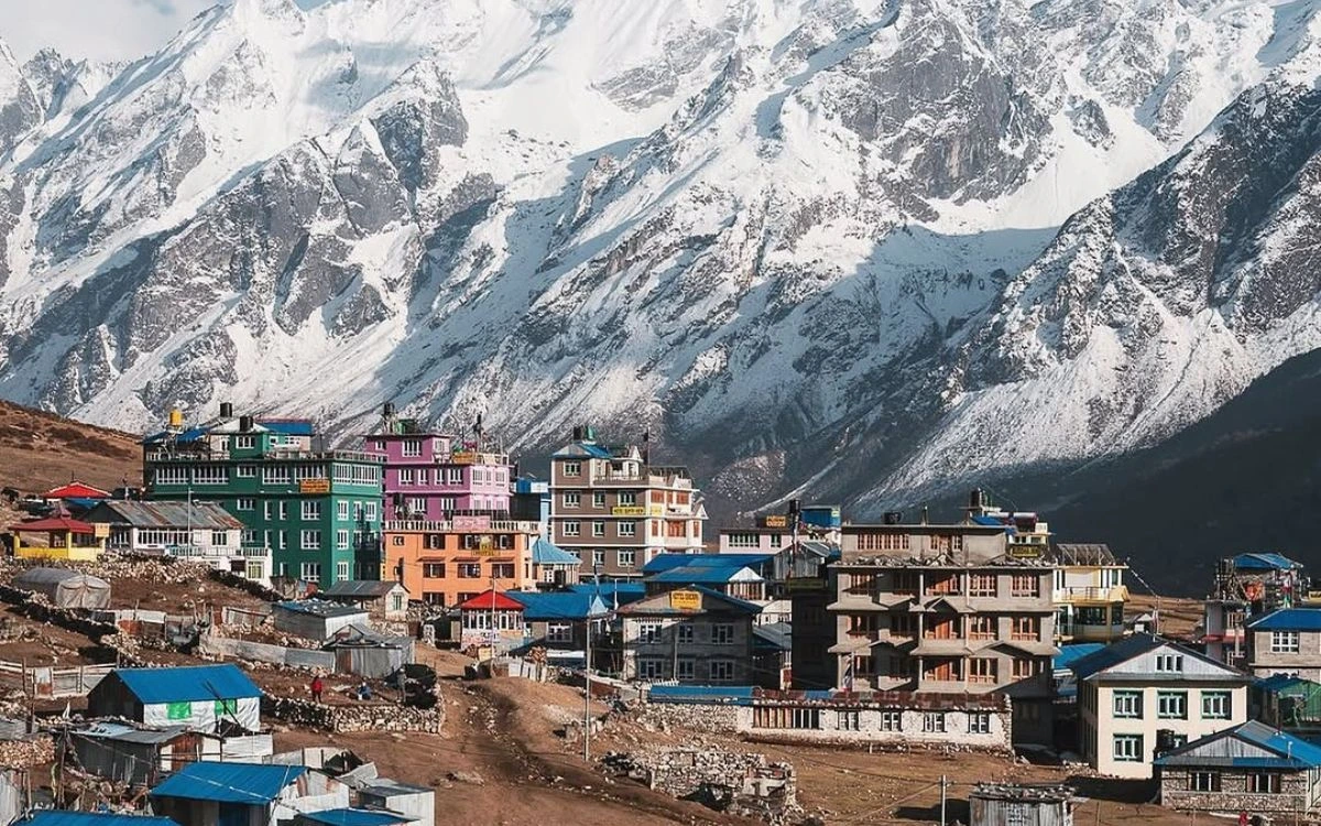 Colorful mountain lodges in Langtang village beneath snowy Himalayan slopes