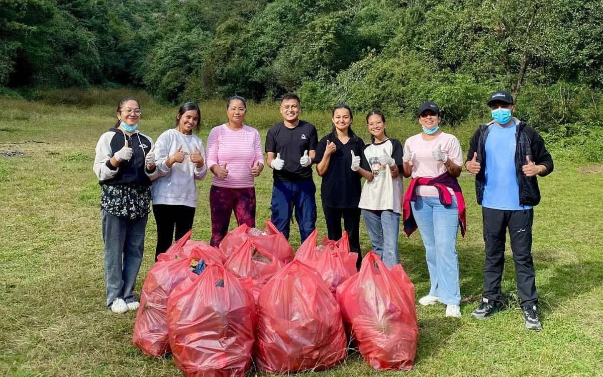 Community cleanup volunteer group with collected trash bags in Nepal