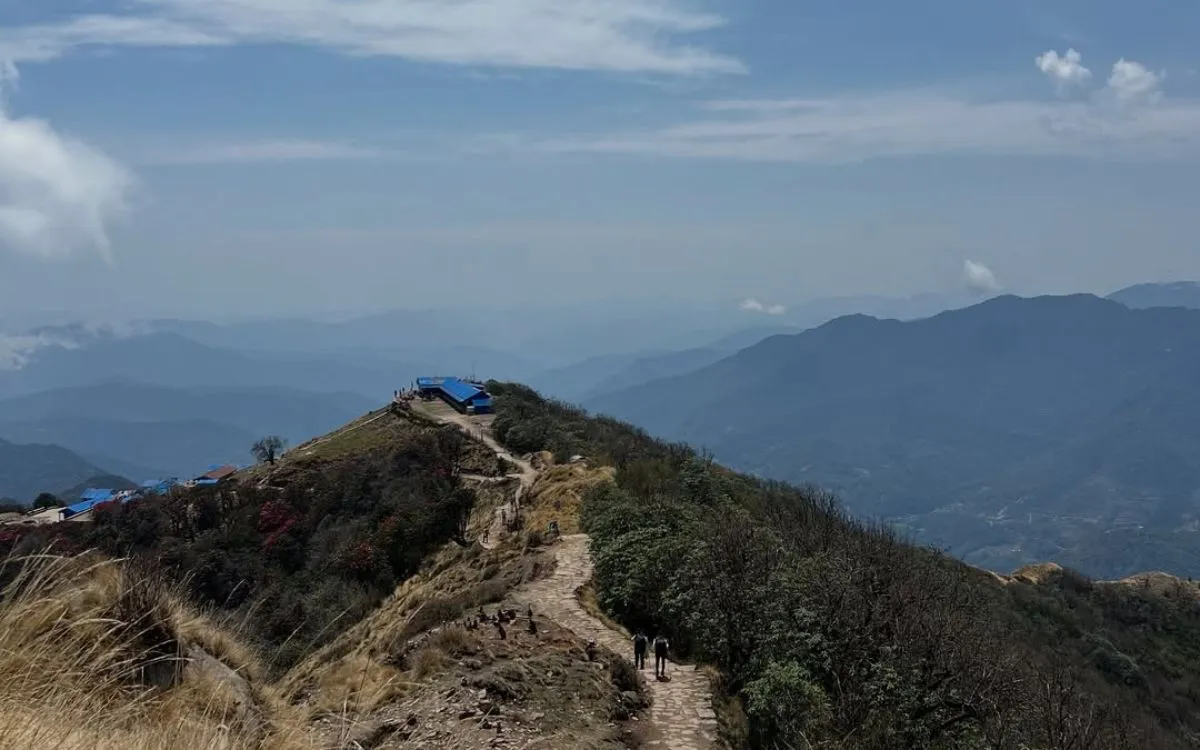 Mountain ridge trail leading to teahouse lodge at Low Camp or High Camp on Mardi Himal trek with view of Annapurna range and Pokhara valley in distance