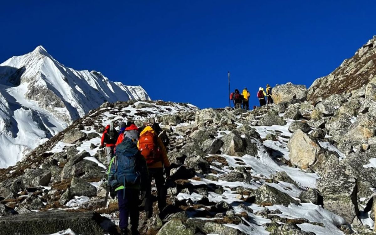 Trekkers ascending Larkya La Pass rocky trail at high altitude Manaslu Circuit trek Nepal Himalayas