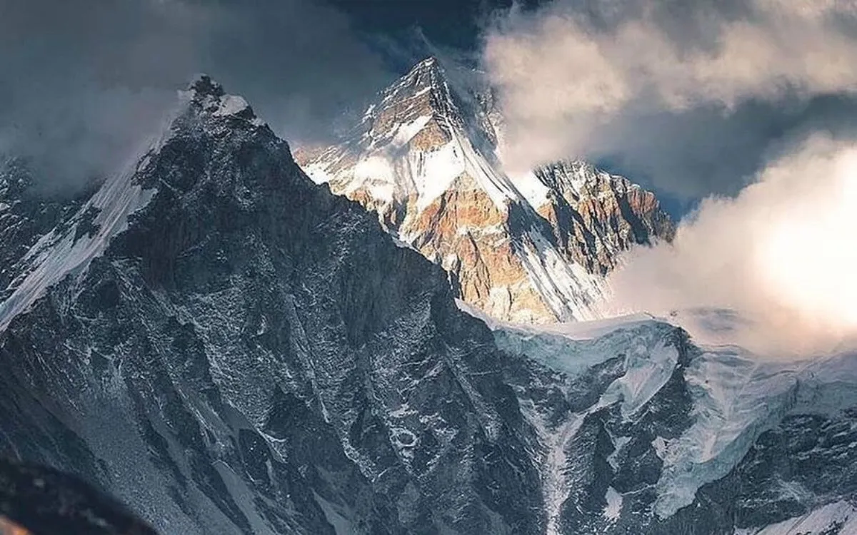Mount Everest peak with snow-covered summit emerging through dramatic clouds