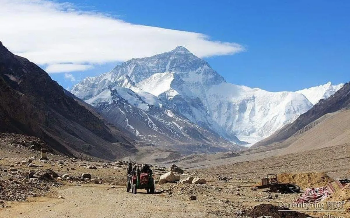 Mount Everest north face view from Tibetan side with rocky valley and scattered equipment in foreground