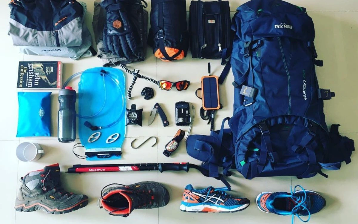 Trekking gear laid out including backpack, boots, and hydration bladder for the Kanchenjunga trek
