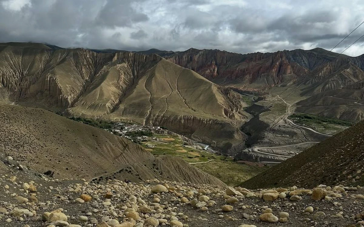 A remote Upper Mustang village nestled in a deep canyon surrounded by dramatically eroded red and brown cliffs