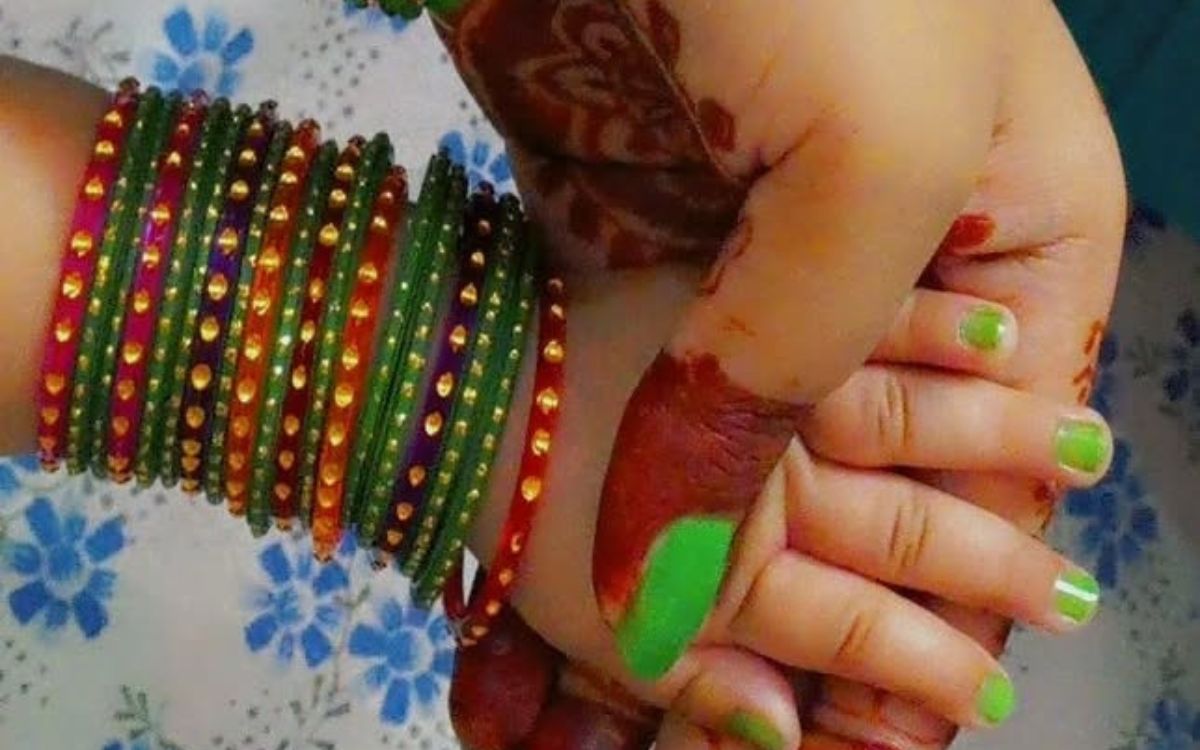 kid hand in teej with green bangles