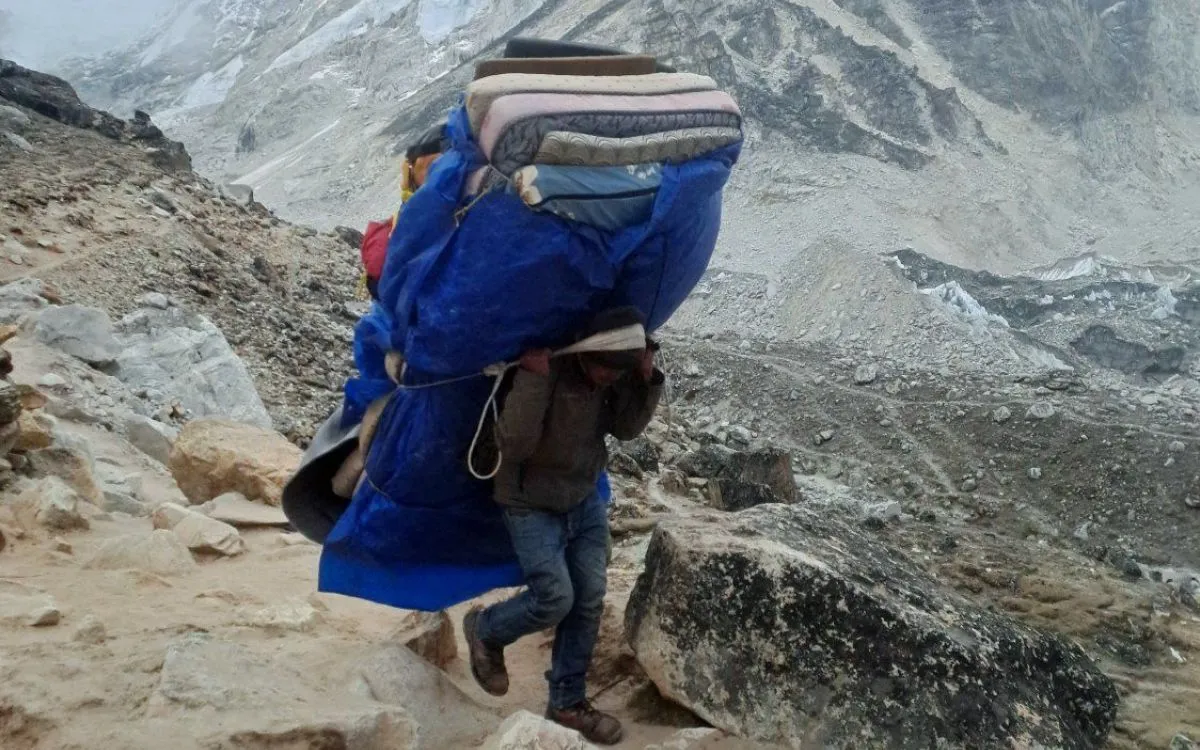 Porter carrying heavy load on Everest trail